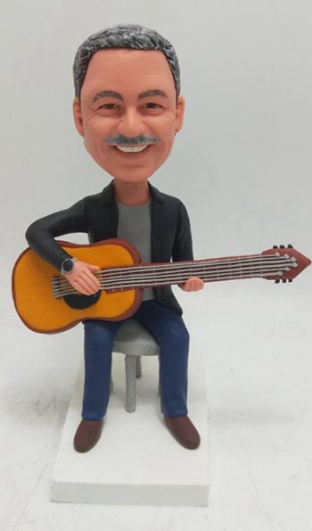 Custom bobblehead sitting with guitar