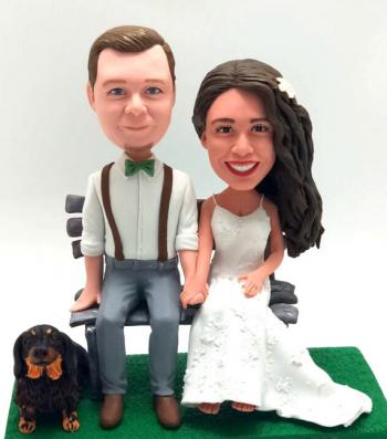 Custom wedding bobbleheads sitting on the bench